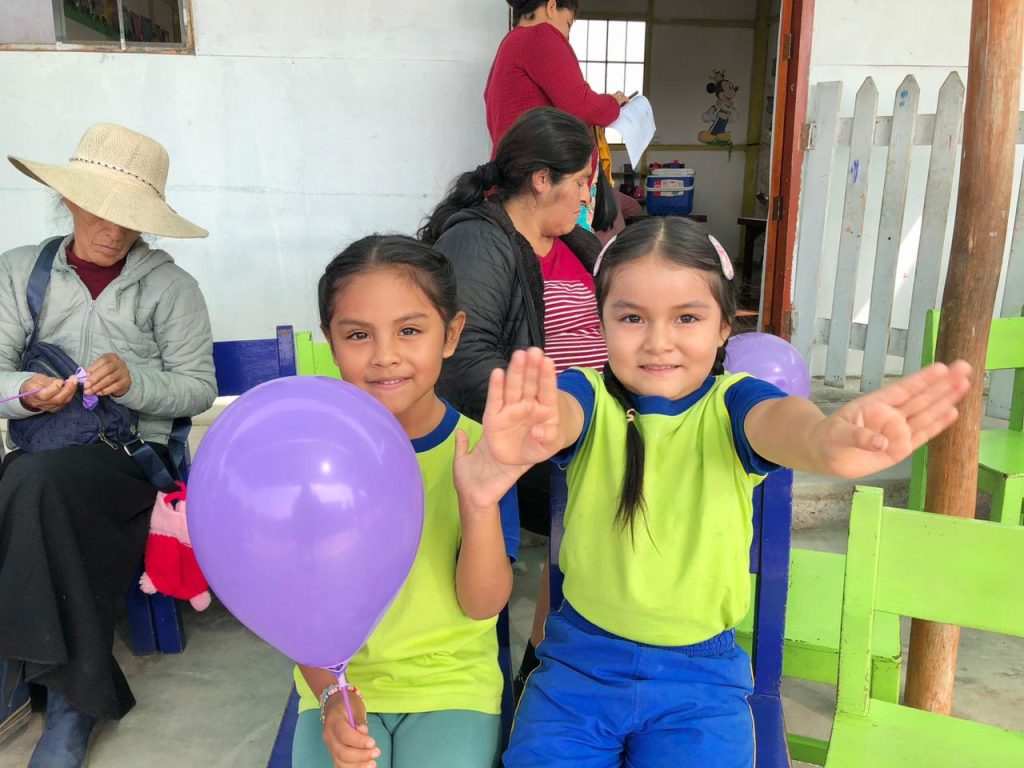 niñas saludando banner