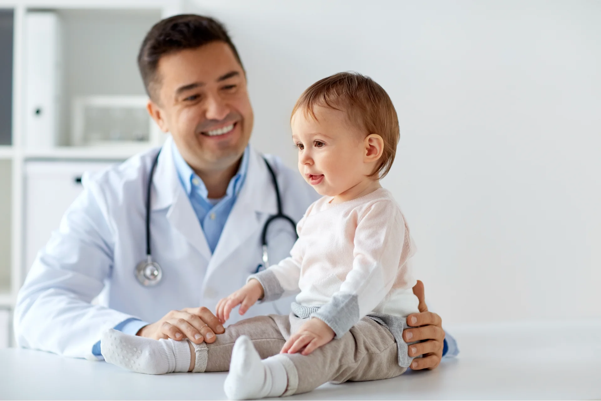 medicine-healtcare-pediatry-people-concept-happy-doctor-pediatrician-holding-baby-medical-exam-clinic 1